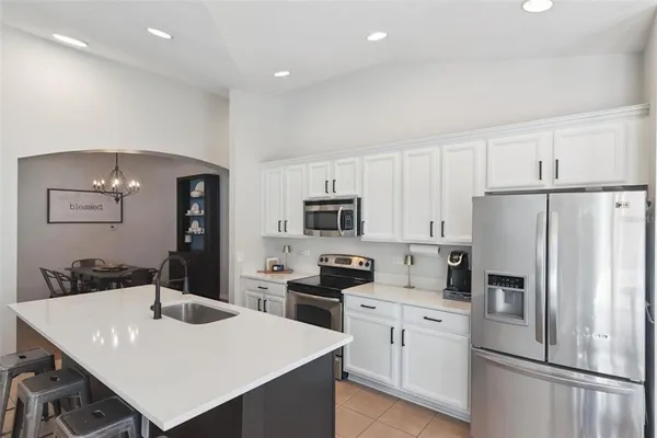 a kitchen with white cabinets and stainless steel appliances