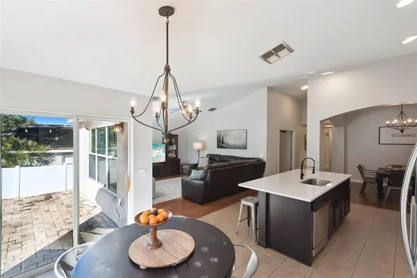 a kitchen with a refrigerator a sink dishwasher with a dining table and chairs
