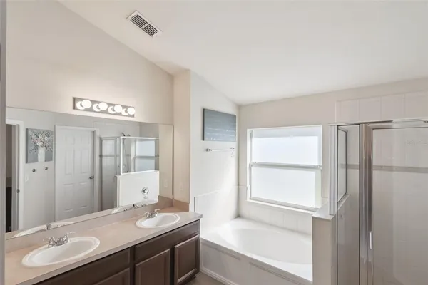 a bathroom with a granite countertop sink and a bathtub