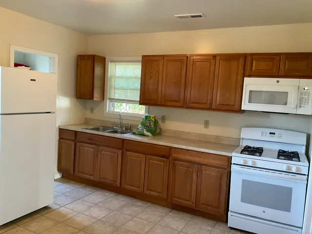 a kitchen with granite countertop cabinets and white appliances