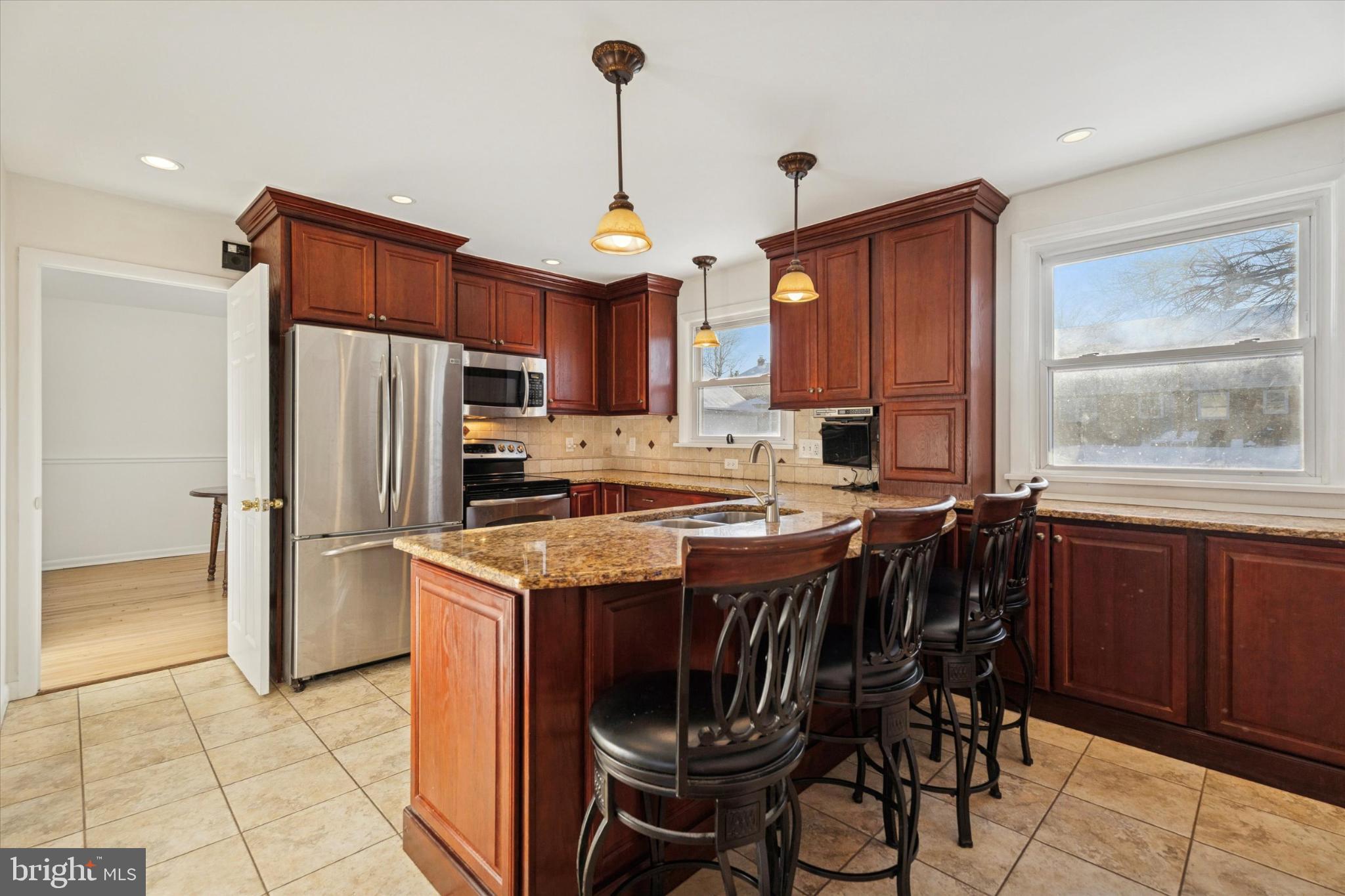 725 Springdell Road King of Prussia, PA 19406 - Photo 12 of 29 a kitchen with stainless steel appliances granite countertop a stove a refrigerator a sink a dining table and chairs