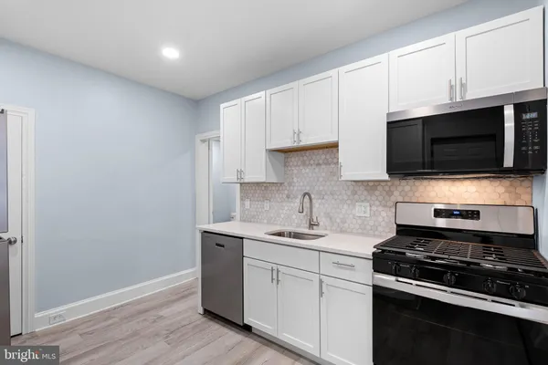 a kitchen with stainless steel appliances a sink a stove a microwave and cabinets
