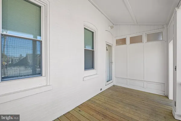 a view of a small space with wooden floor and a window
