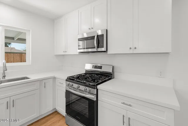 a kitchen with white cabinets and appliances