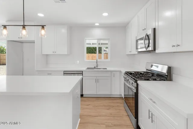 a kitchen with a stove a sink and a refrigerator