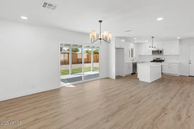 a view of a kitchen with a sink wooden floor and a refrigerator