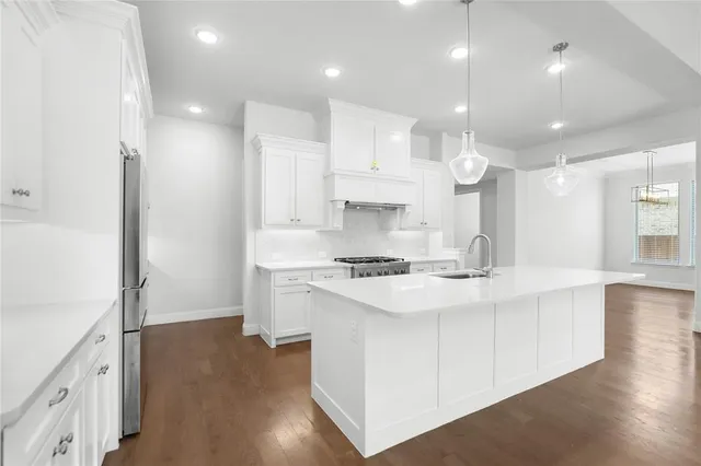a kitchen with kitchen island a sink stainless steel appliances and cabinets
