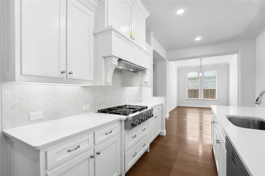 3811 Pepper Grass Lane Prosper, TX 75078 - Photo 20 of 40 a kitchen with granite countertop a sink stove and cabinets