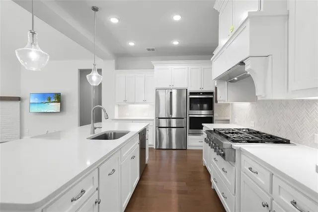 a kitchen with white cabinets and stainless steel appliances