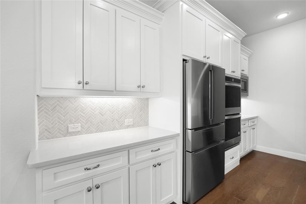 3811 Pepper Grass Lane Prosper, TX 75078 - Photo 22 of 40 a kitchen with stainless steel appliances white cabinets and a refrigerator