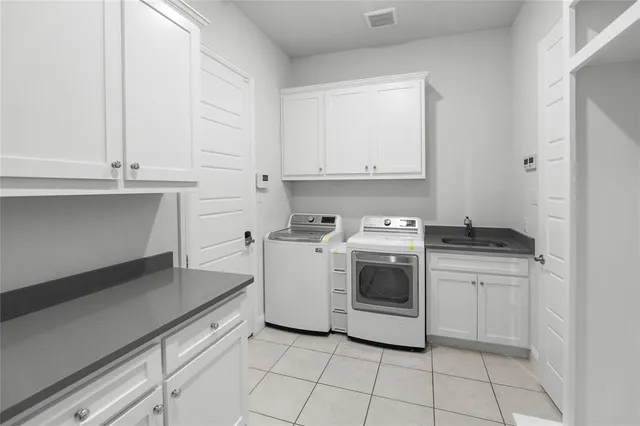 a utility room with sink dryer and washer