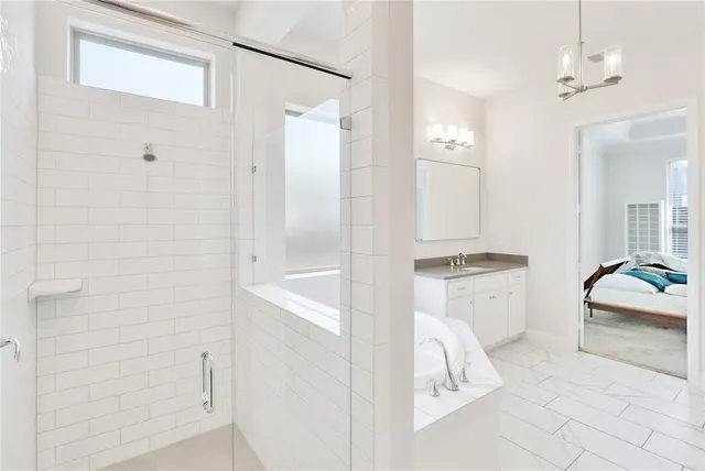 a en suite bathroom with a granite countertop tub sink and mirror