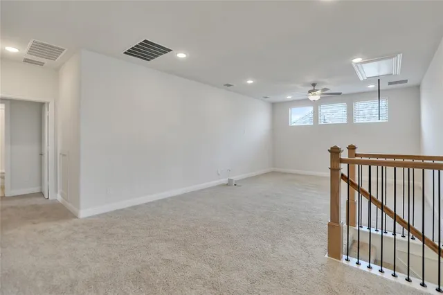 an empty room with a ceiling fan and a chandelier fan