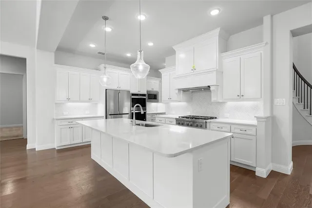 a view of a kitchen with a sink and wooden floor