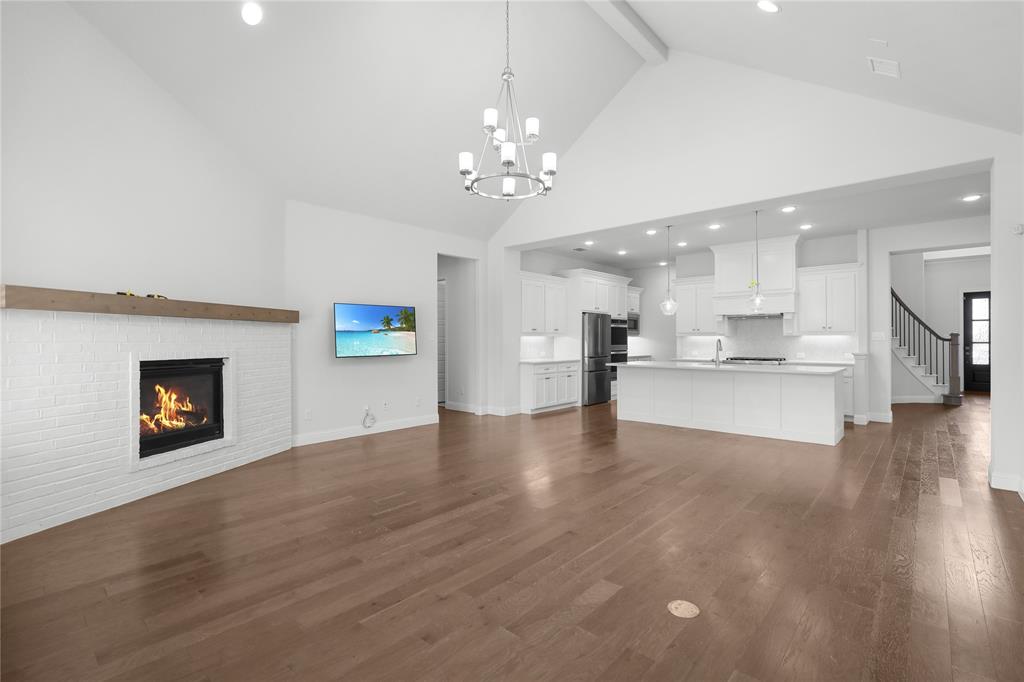 3811 Pepper Grass Lane Prosper, TX 75078 - Photo 7 of 40 a view of an empty room and kitchen with wooden floor