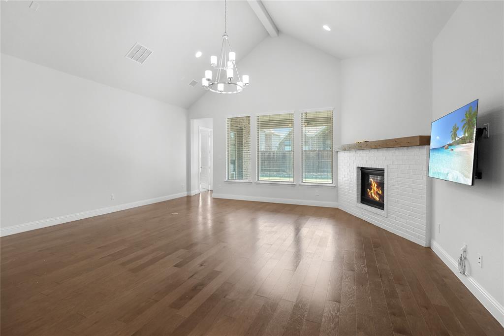 3811 Pepper Grass Lane Prosper, TX 75078 - Photo 8 of 40 a view of an empty room with wooden floor and fireplace