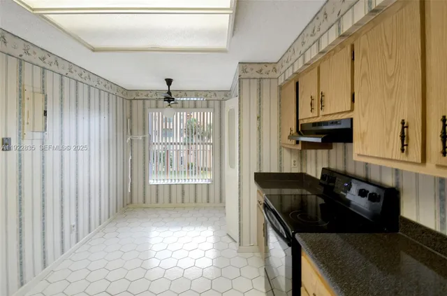 a kitchen with granite countertop a stove a sink and a microwave