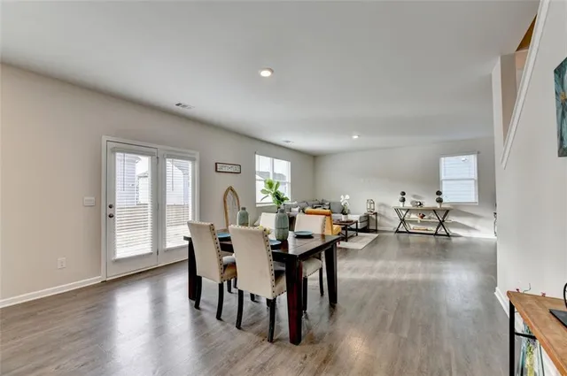 a kitchen with stainless steel appliances a dining table chairs microwave and refrigerator