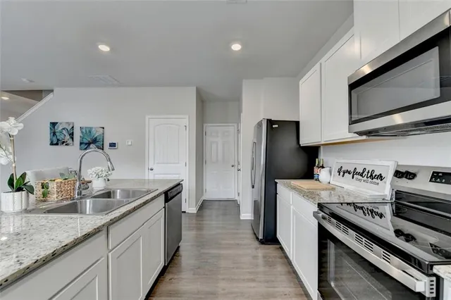 a kitchen with granite countertop counter top space a sink stainless steel appliances and cabinets