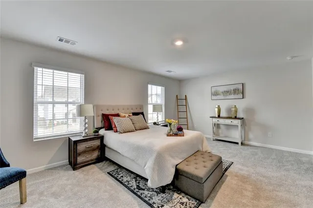 a bedroom with a bed a couch and dresser