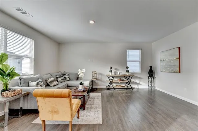 a living room with furniture and a wooden floor