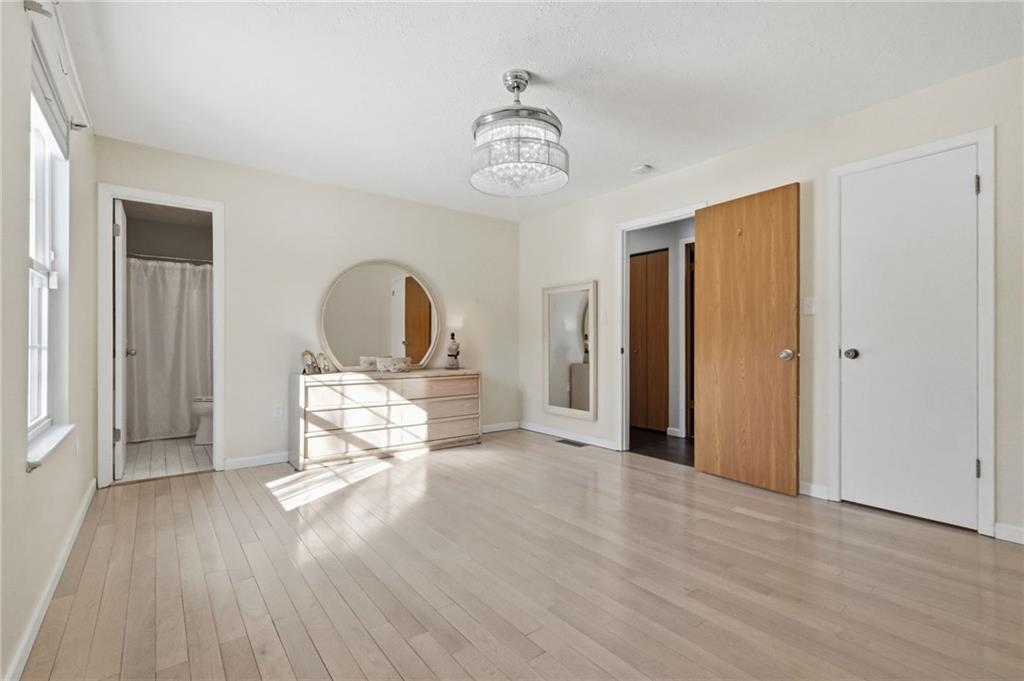 3561 Cedar Ridge Road Allison Park, PA 15101 - Photo 29 of 50 A serene bedroom with bamboo flooring, an en suite bath, and a stylish fandelier—a ceiling fan with chandelier design.