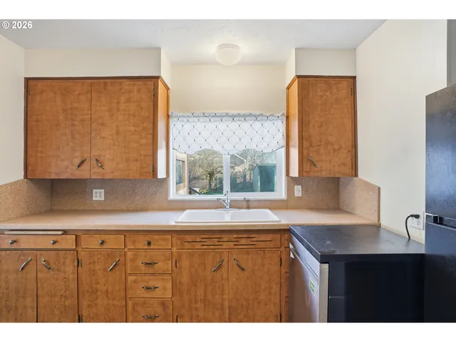 a kitchen with a sink a window and a counter top space