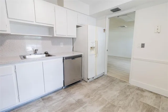 a kitchen with white cabinets and white appliances