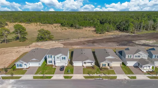 an aerial view of residential houses with outdoor space and ocean view