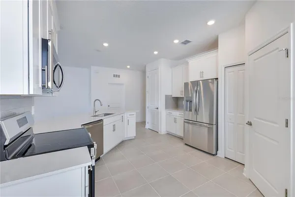 a kitchen with white cabinets and stainless steel appliances