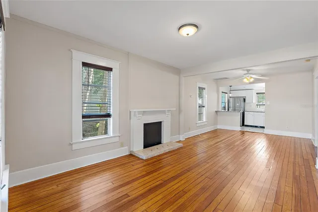 a view of empty room with wooden floor and fireplace