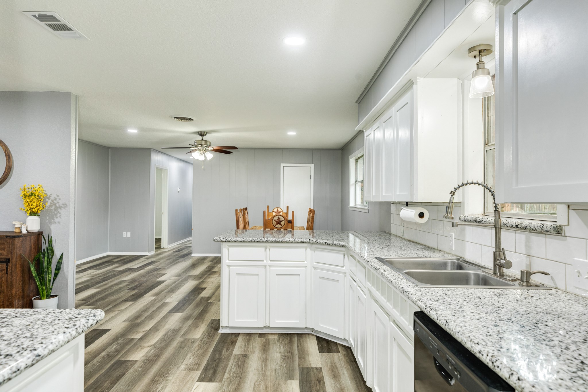 908 West Mulberry Street Angleton, TX 77515 - Photo 10 of 22 a kitchen with a sink dishwasher a stove and white cabinets with wooden floor
