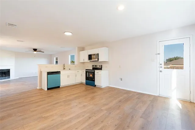 a kitchen with granite countertop a stove top oven and cabinets