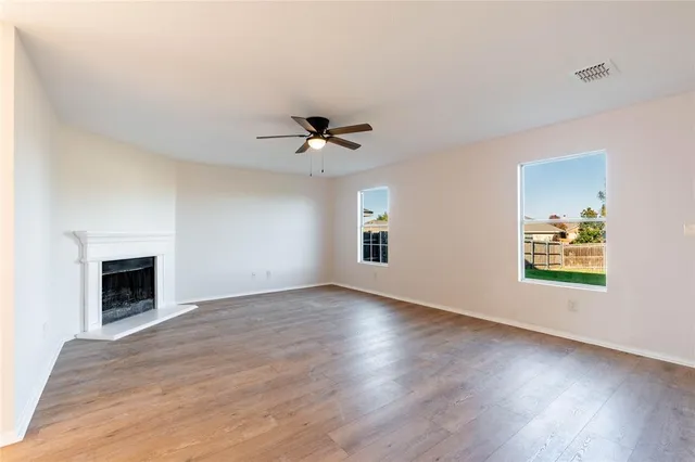 a view of an empty room with a fireplace and a window