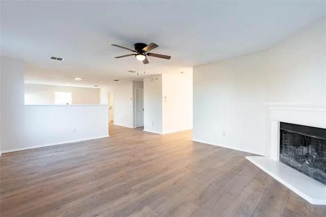 a view of empty room with wooden floor and fireplace