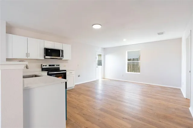 a kitchen with granite countertop a refrigerator stove top oven and sink