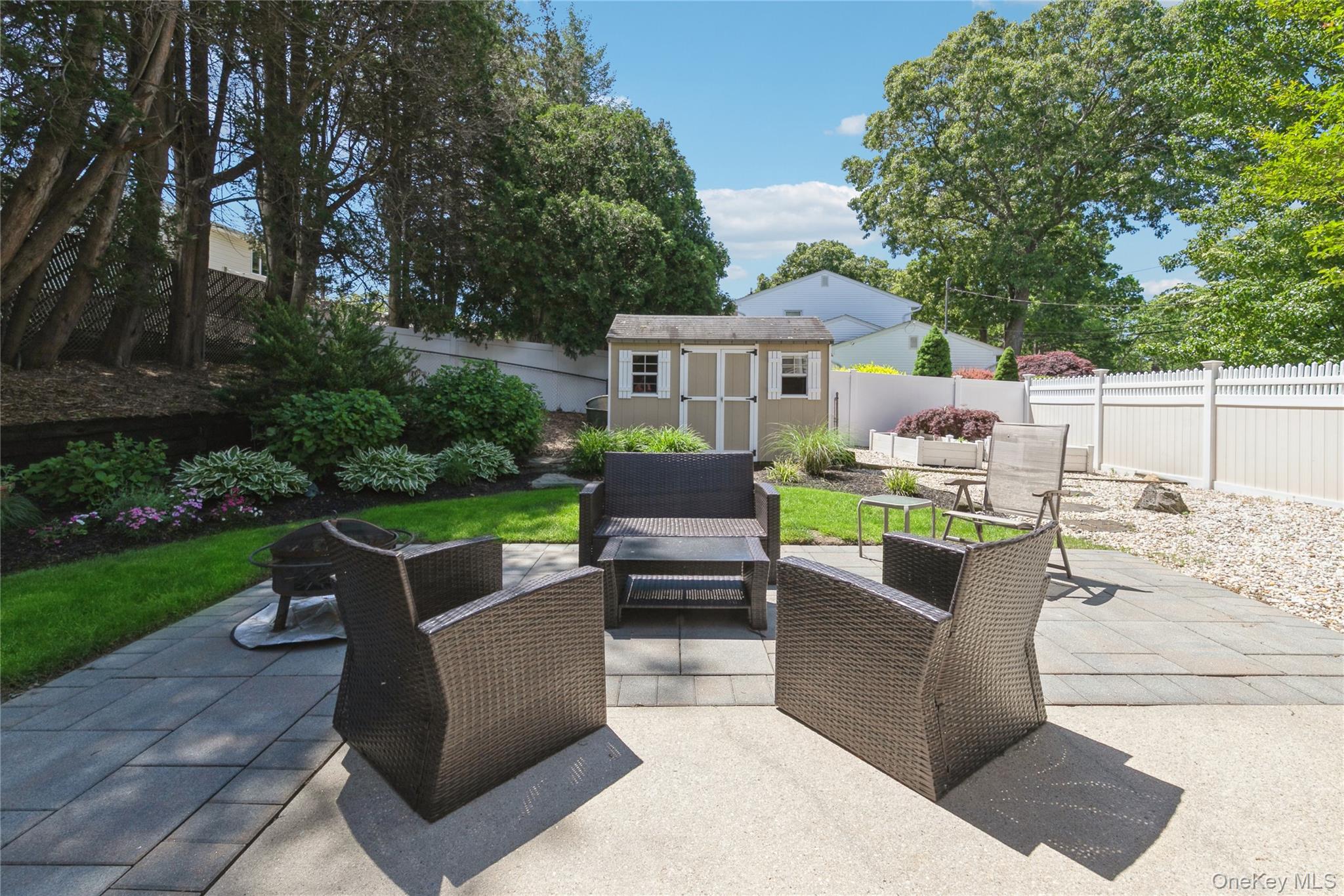 115 Clarendon Road Ronkonkoma, NY 11779 - Photo 39 of 45 Expansive paver patio with a separate gravel area and a dedicated lawn space