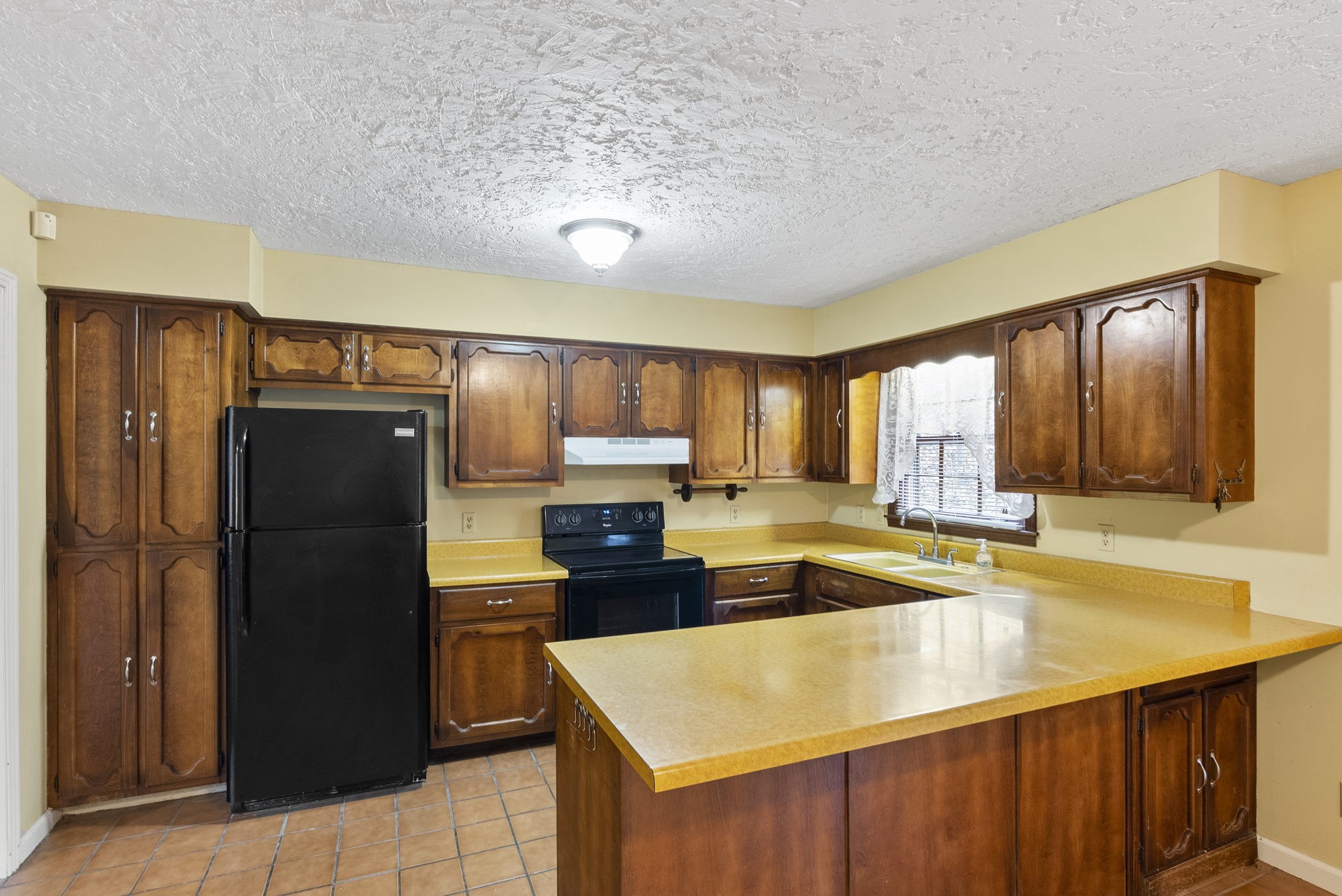 1628 Butler Mill Hollow Road Bethpage, TN 37022 - Photo 7 of 14 a kitchen with a refrigerator a sink and cabinets