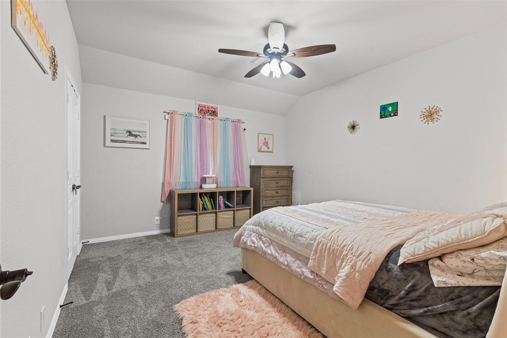 1013 Stockton Drive Godley, TX 76044 - Photo 18 of 22 a bedroom with a bed and a chandelier