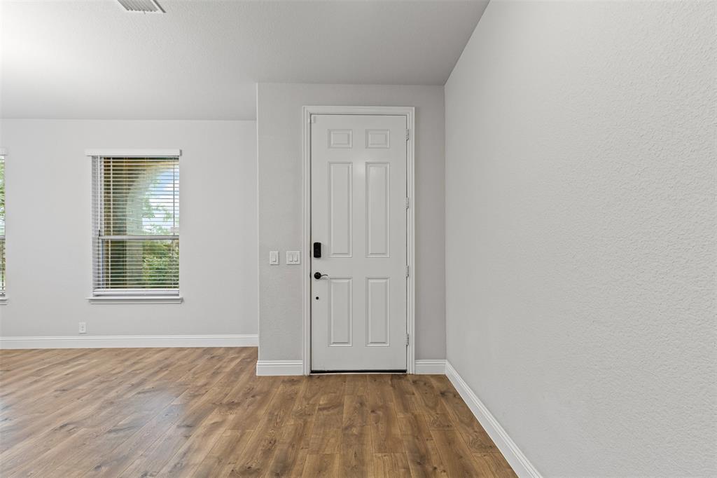 1013 Stockton Drive Godley, TX 76044 - Photo 2 of 22 an empty room with wooden floor and windows