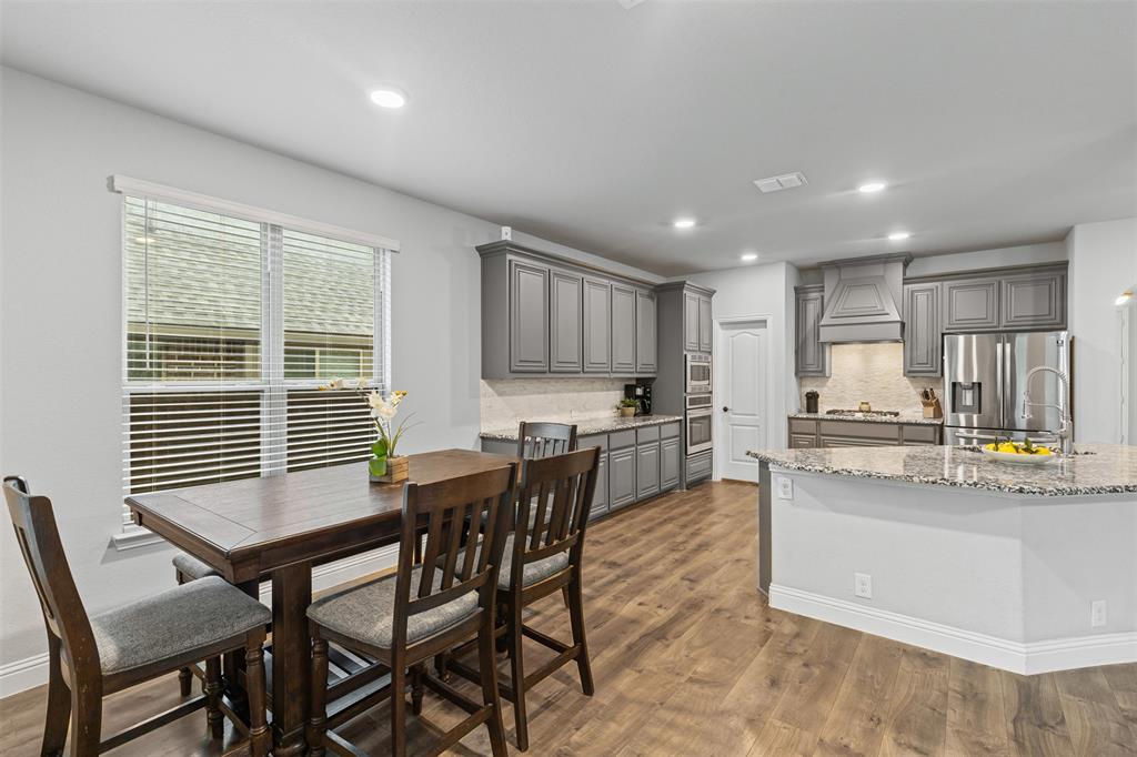 1013 Stockton Drive Godley, TX 76044 - Photo 8 of 22 a kitchen with stainless steel appliances kitchen island granite countertop a dining table chairs stove refrigerator and cabinets