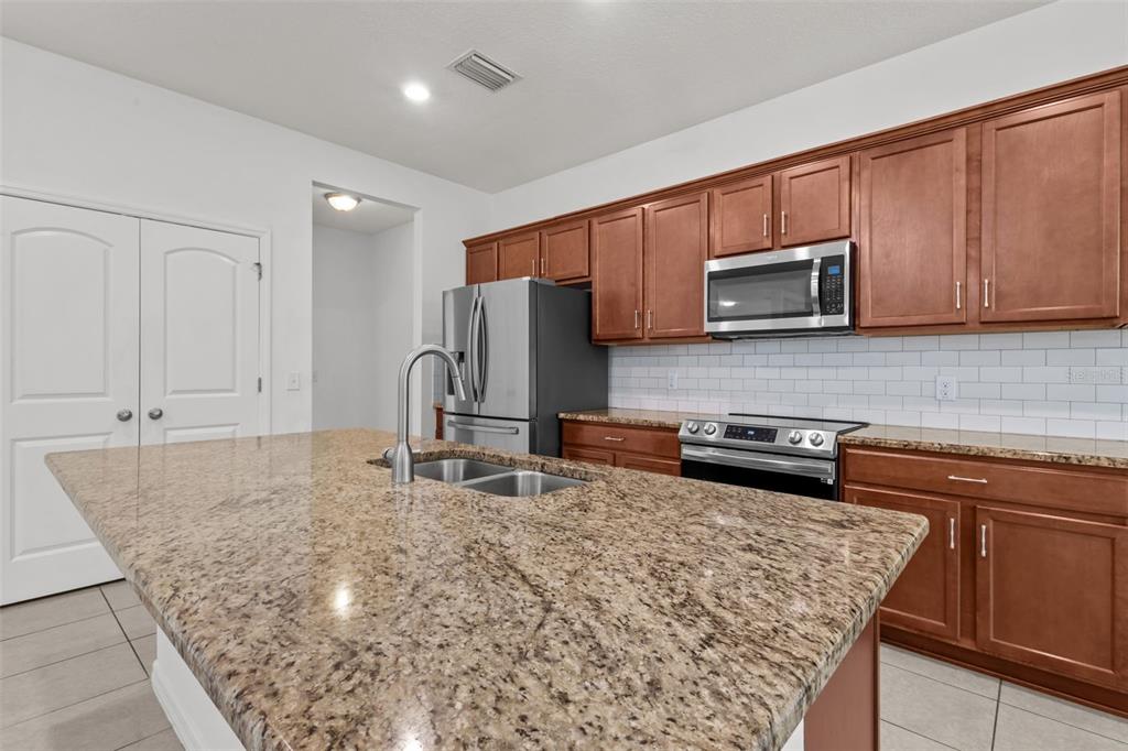 12124 Lake Boulevard Trinity, FL 34655 - Photo 13 of 31 a kitchen with stainless steel appliances granite countertop a stove microwave and sink