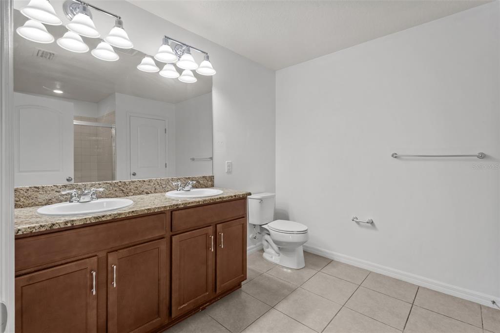 12124 Lake Boulevard Trinity, FL 34655 - Photo 21 of 31 a bathroom with a granite countertop sink and a toilet
