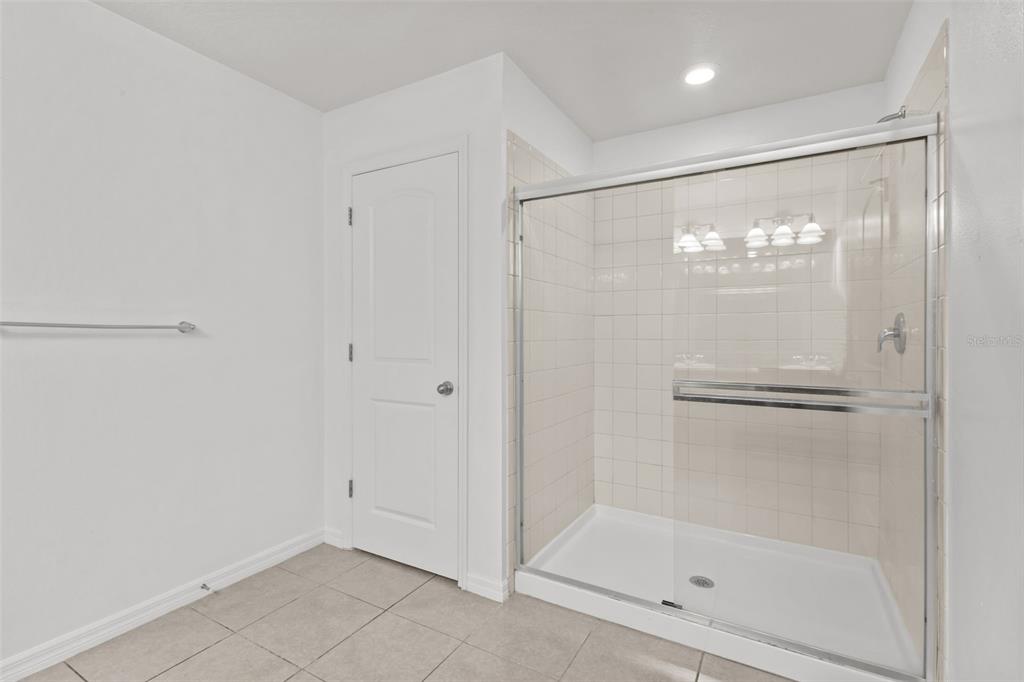 12124 Lake Boulevard Trinity, FL 34655 - Photo 22 of 31 a bathroom with a glass shower door