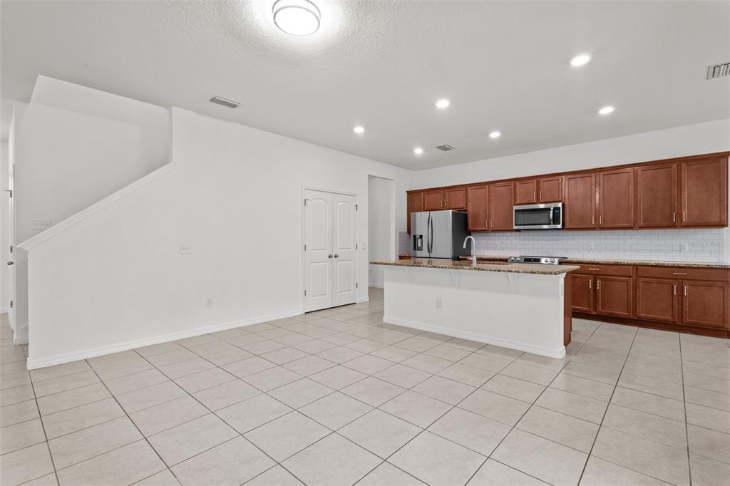 12124 Lake Boulevard Trinity, FL 34655 - Photo 10 of 31 a large kitchen with granite countertop a white stove top oven and white cabinets