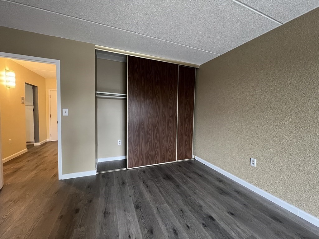 1550 Worcester Road, Unit 114 Framingham, MA 01702 - Photo 11 of 29 a view of an empty room with wooden floor and a window