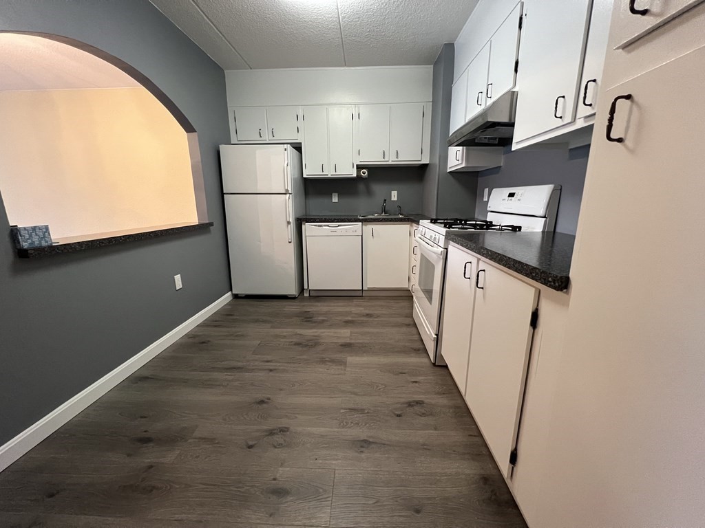 1550 Worcester Road, Unit 114 Framingham, MA 01702 - Photo 8 of 29 a kitchen with stainless steel appliances granite countertop a refrigerator a sink dishwasher a stove and a microwave oven with wooden floor