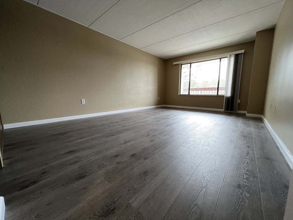 1550 Worcester Road, Unit 114 Framingham, MA 01702 - Photo 10 of 29 an empty room with wooden floor and windows