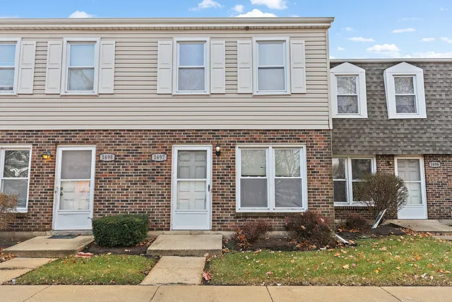 a front view of a house with garden and garage