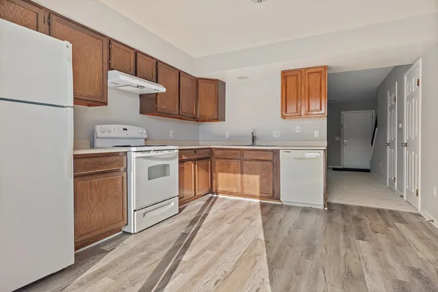 a kitchen with stainless steel appliances granite countertop a stove a sink and a refrigerator